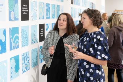 Prof. Ingrid Hess discussing her exhibition with attendees.